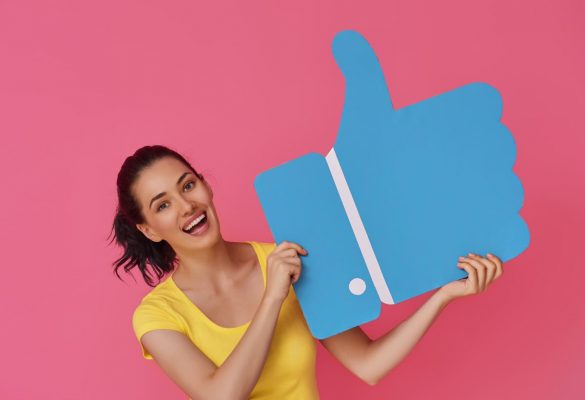Woman holding Facebook 'tumbs up' icon